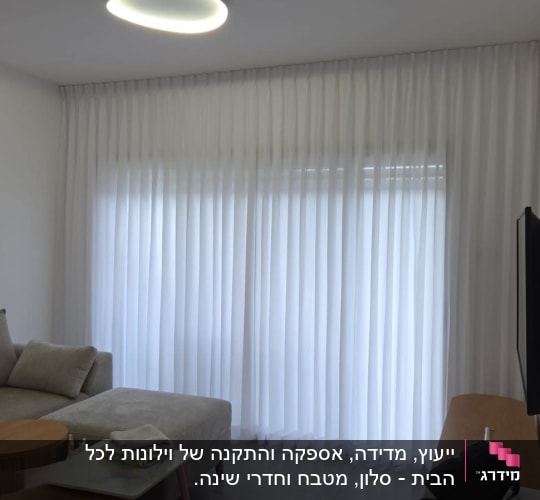 וילון לבן בסלון עם ספה ושולחן קטן